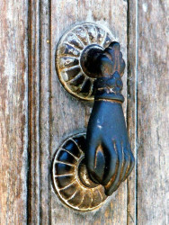 1 Old brass hand door knocker on an old door in Guatemala 800
