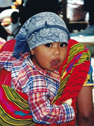 9 guatemalan child getting a ride through the market place